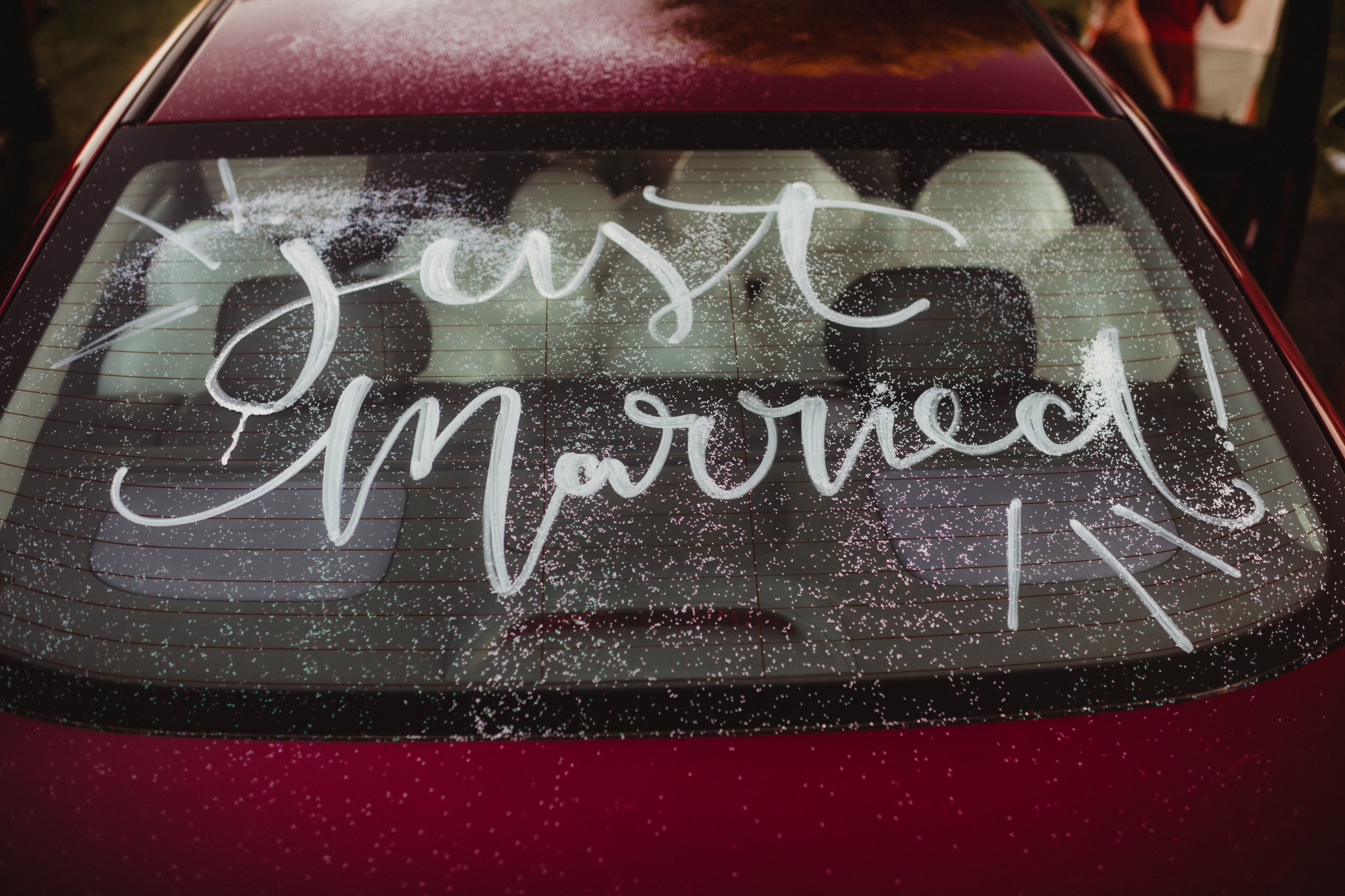 "Just Married" is written on the rear window of a car
