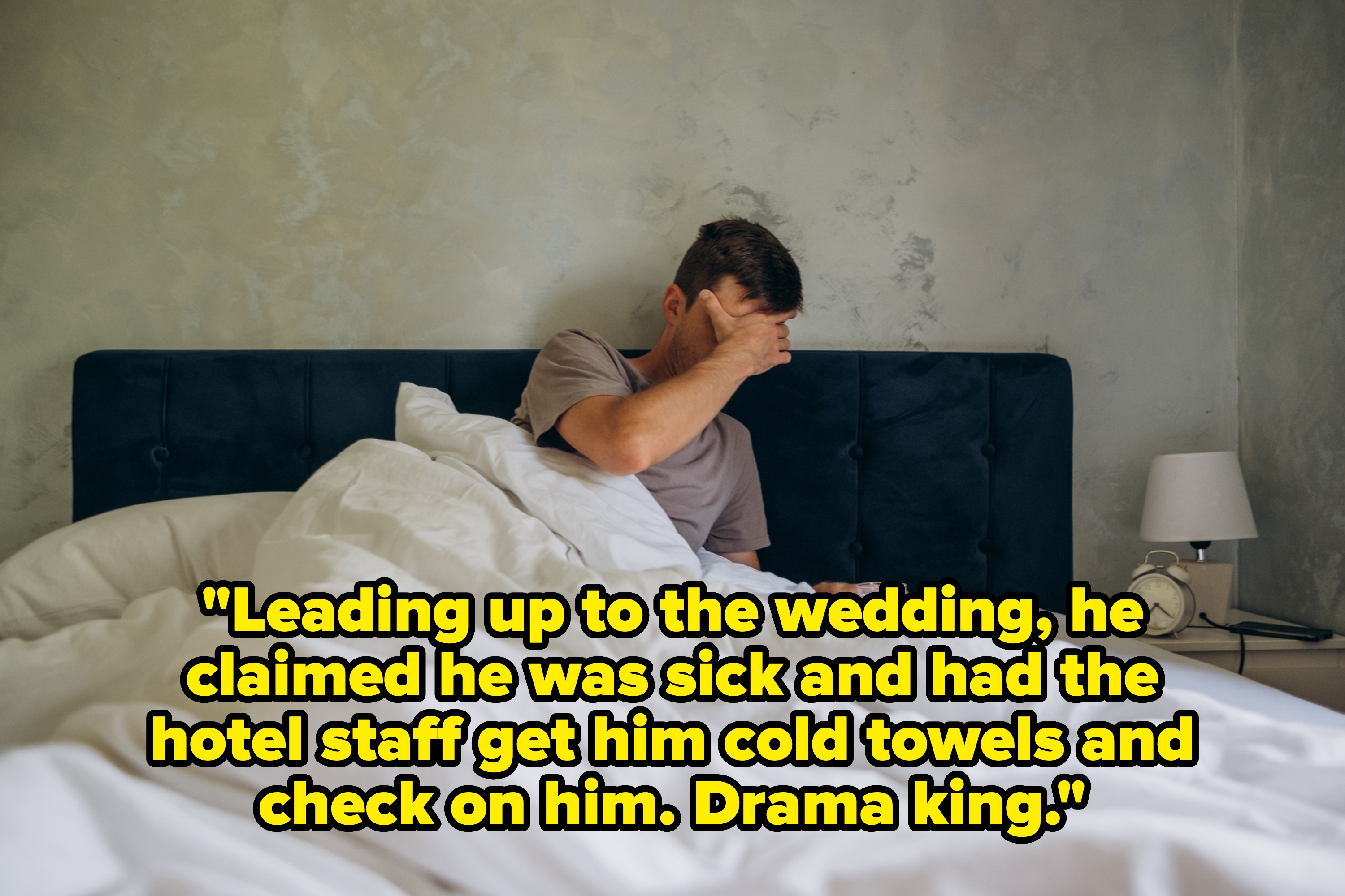 Person sitting up in bed with a hand on their face, appearing tired or stressed, in a bedroom setting