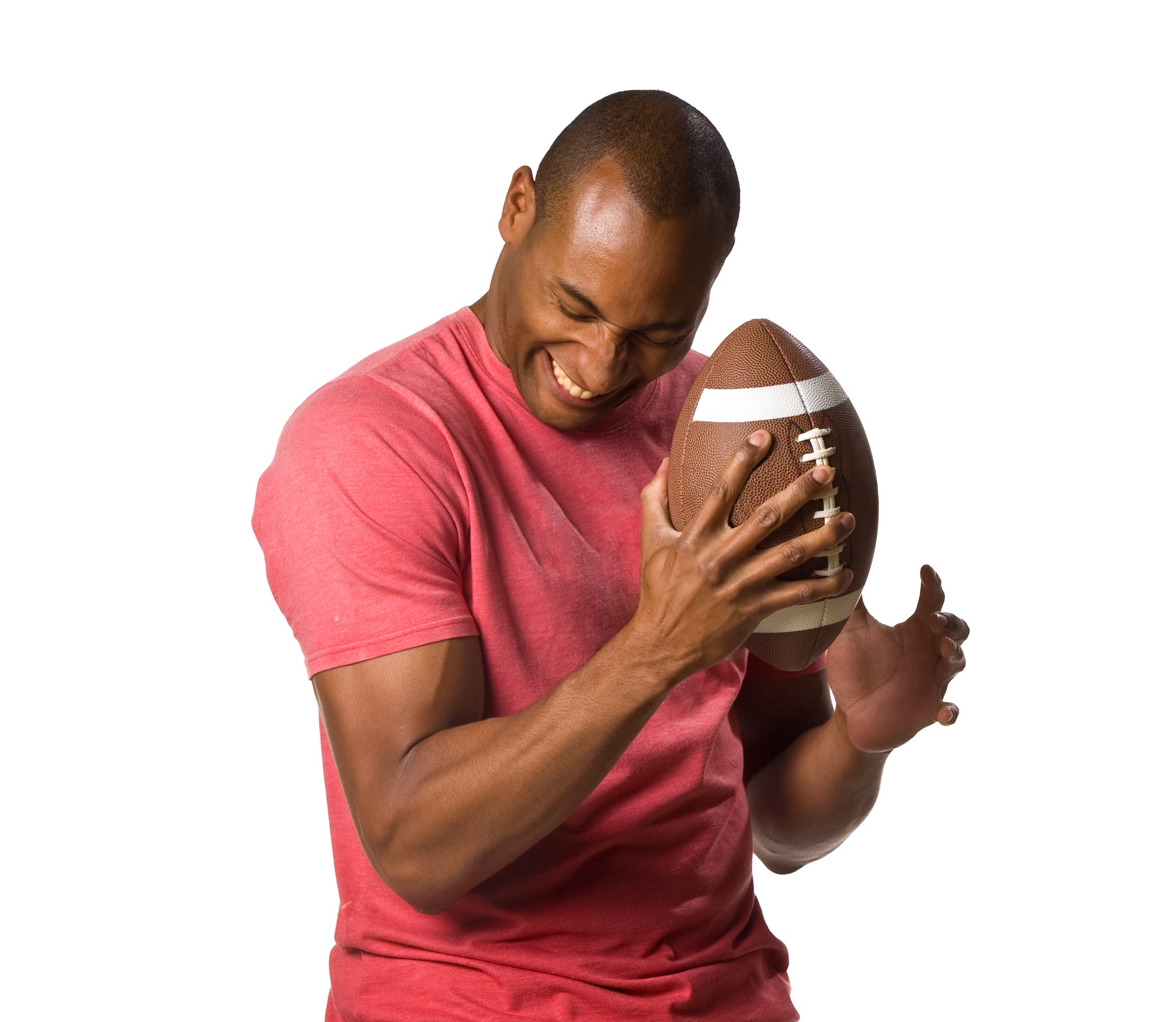 Person playfully hugging a football, wearing a casual t-shirt and jeans, smiling