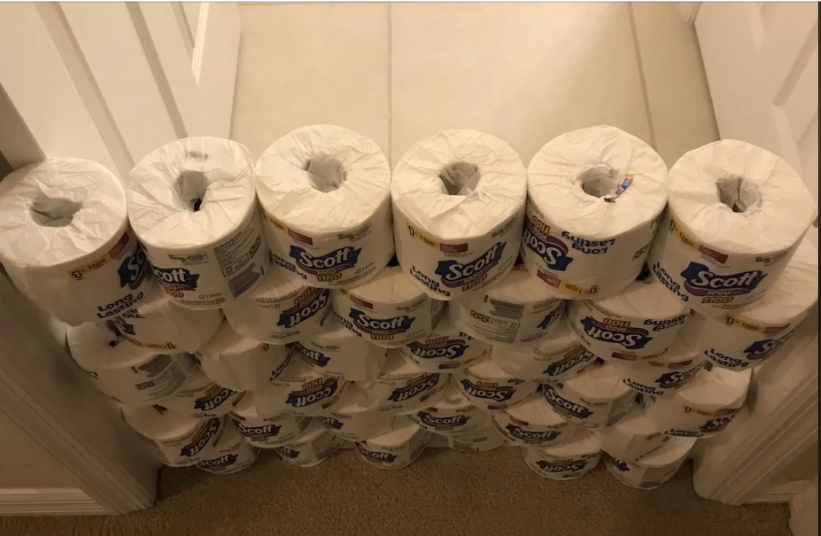 A stack of toilet paper rolls fills a doorway, blocking entry