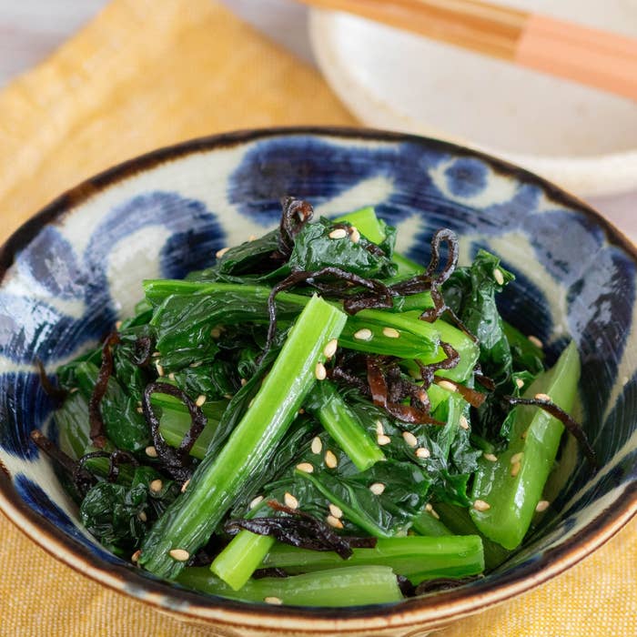 お皿に盛られたほうれん草と海藻のサラダ、白ごまがトッピングされています。