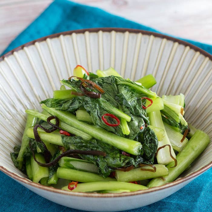 青菜と赤唐辛子、ごま油で炒めた料理が皿に盛られている。