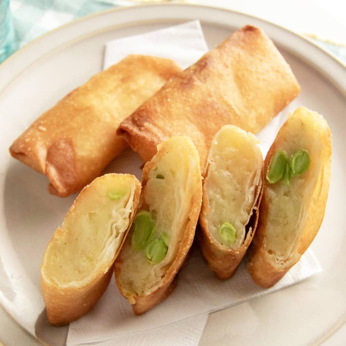 皿に乗った春巻き、切り口から見えるエンドウ豆とその他の具材。