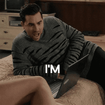 Person lying on a bed, wearing a striped sweater, typing on a laptop, looks surprised. Text on the image: &quot;I'm trying very hard not to connect with people right now.&quot;