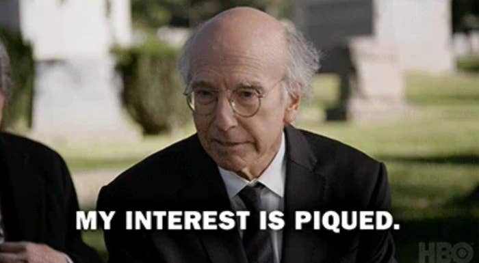 Older man with glasses and a serious expression, outdoors with blurred background. Overlaid text reads, "MY INTEREST IS PIQUED."