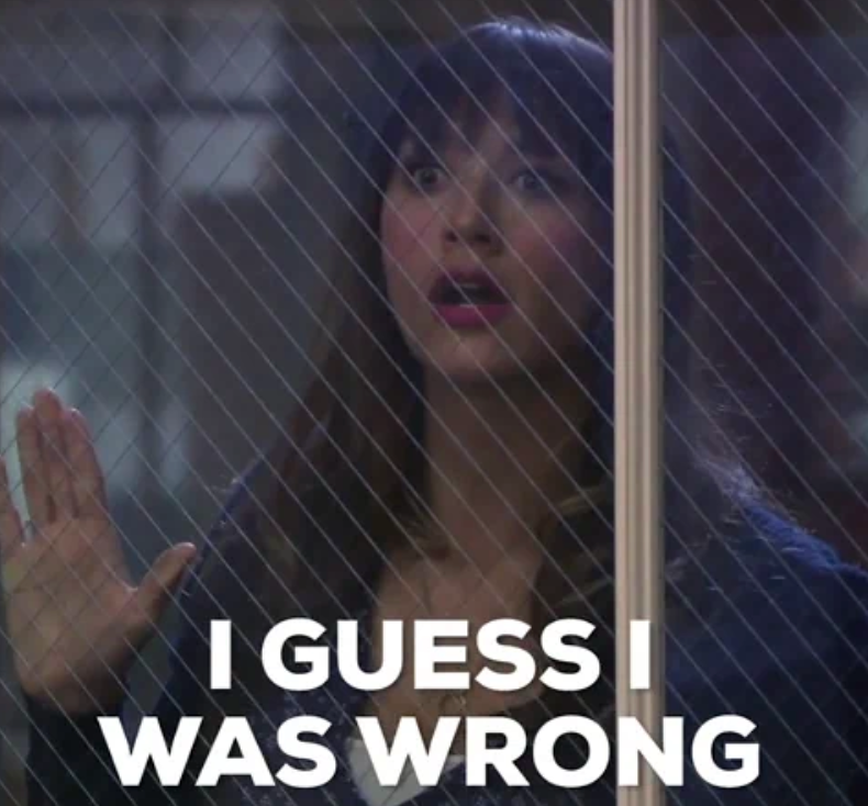 A woman with bangs looks through a window with her hand raised, appearing surprised. Text on image reads "I guess I was wrong."