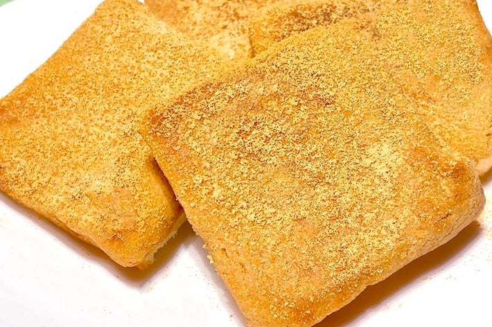 白い皿にきな粉をまぶした4つのモチトーストが置かれています。