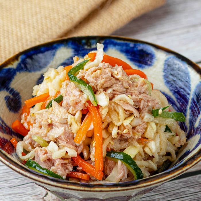 美しく盛り付けられた野菜とツナのサラダが陶器の器に入っています。