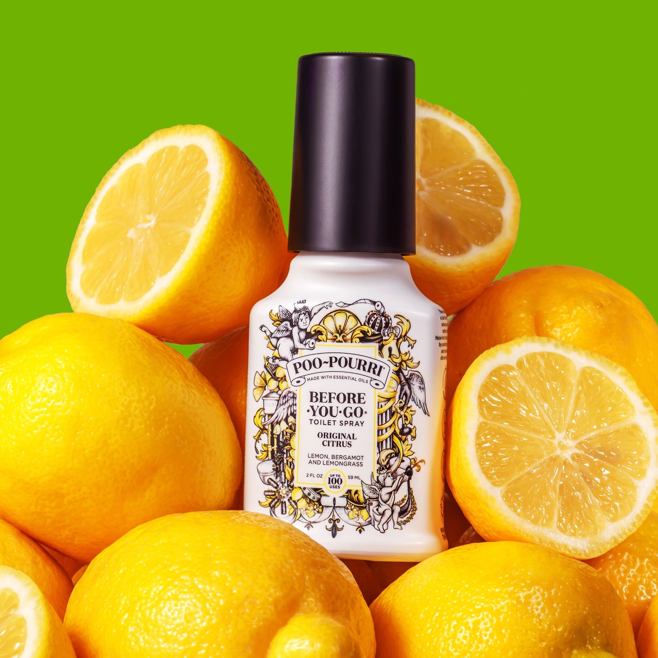 Botol semprot toilet poo-pourri dikelilingi oleh lemon, dengan latar belakang hijau