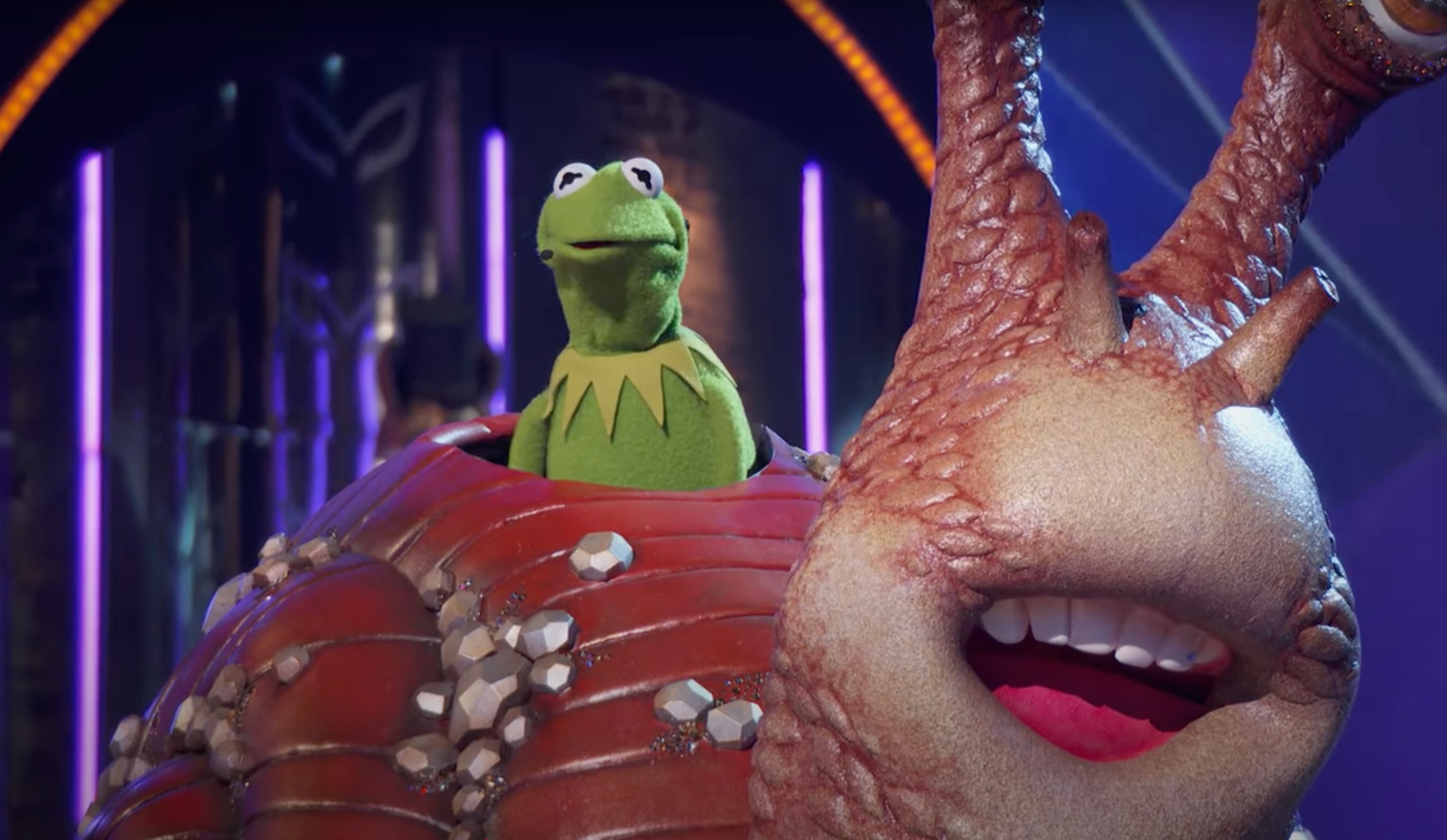 Kermit the Frog peeks out from inside a large snail costume during an episode of "The Masked Singer"