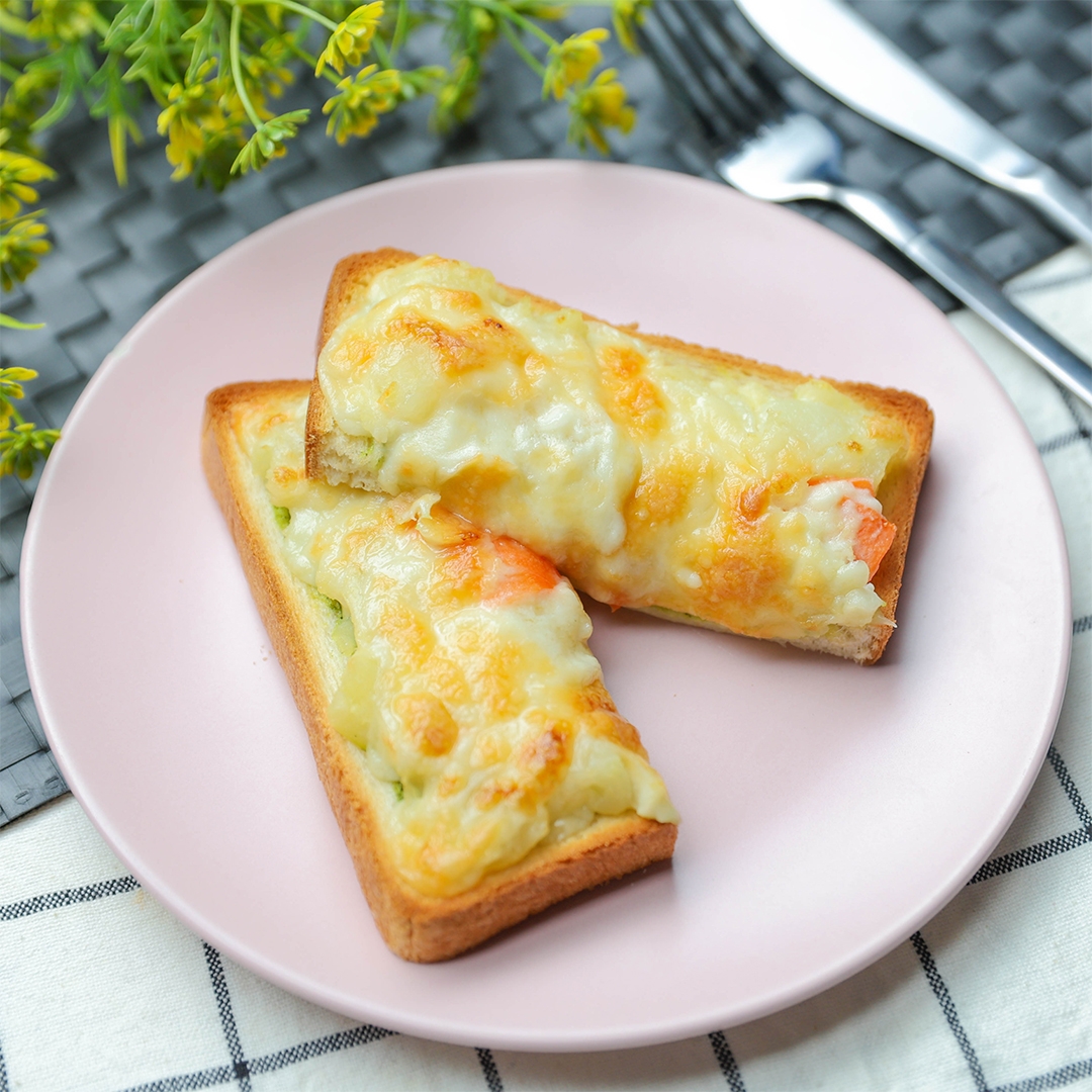 皿にのったポテサラバジルトースト。背景に花とカトラリーあり。