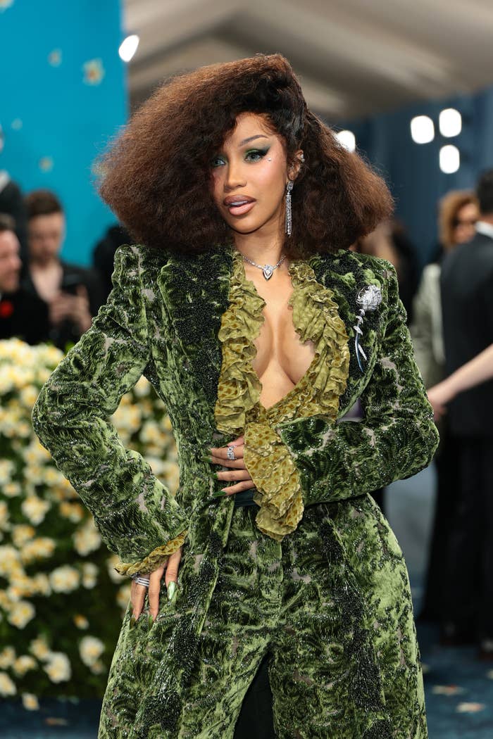 Cardi B  successful  a velvet suit   with a ruffled garment  posing confidently astatine  the Met Gala