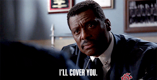 Man in a uniform in an office setting, saying, "I'll cover you" with a serious expression.