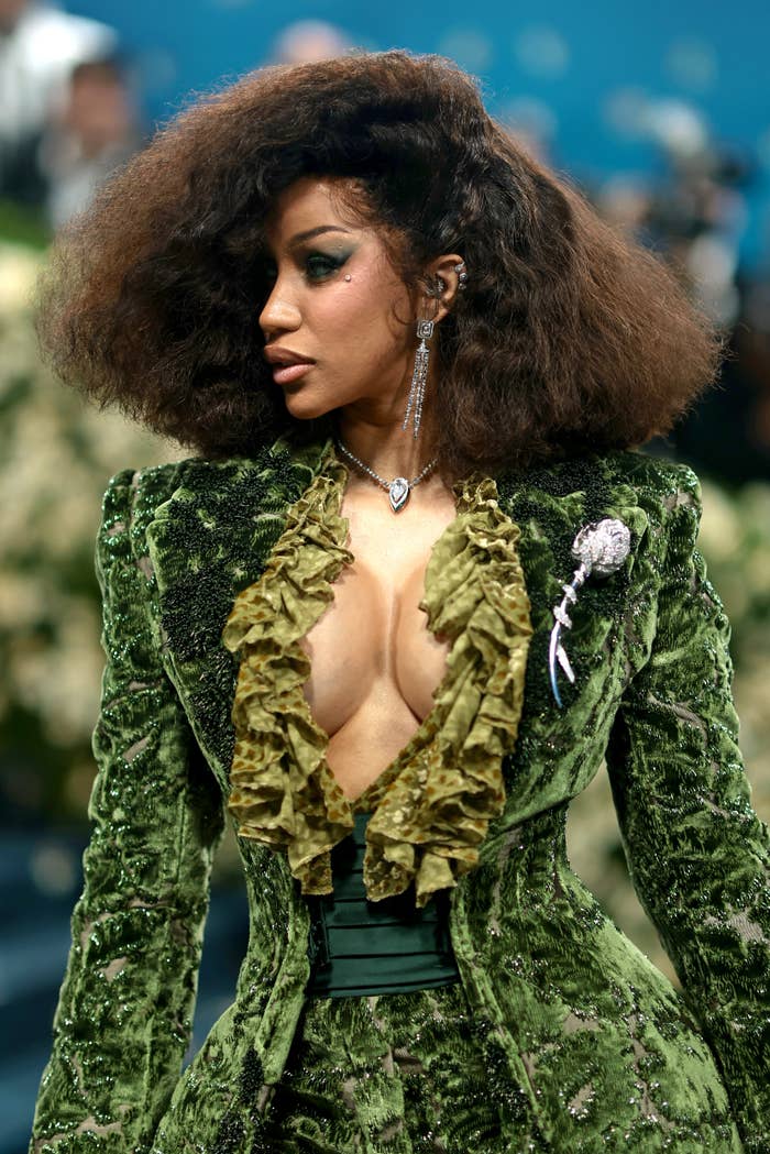 Cardi B successful  a velvet suit   with a ruffled garment  posing confidently astatine  the Met Gala