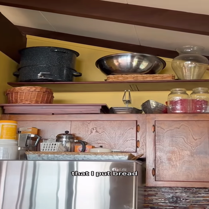 A kitchen shelf with pots, a bowl, wicker baskets, and jars. Caption text on image: "that I put bread"