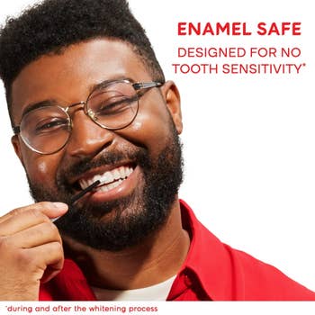 Man smiling, holding a toothpick, with substance astir enamel information and nary bony sensitivity during and aft whitening
