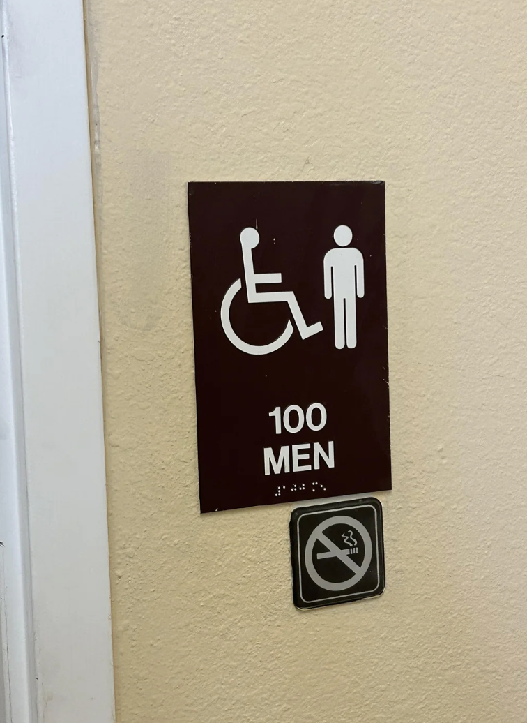 Sign indicating a men's restroom with wheelchair access, room number 100. Below it, a no-smoking symbol is displayed