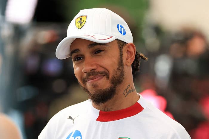 Person in a casual sports outfit and cap at an event, smiling