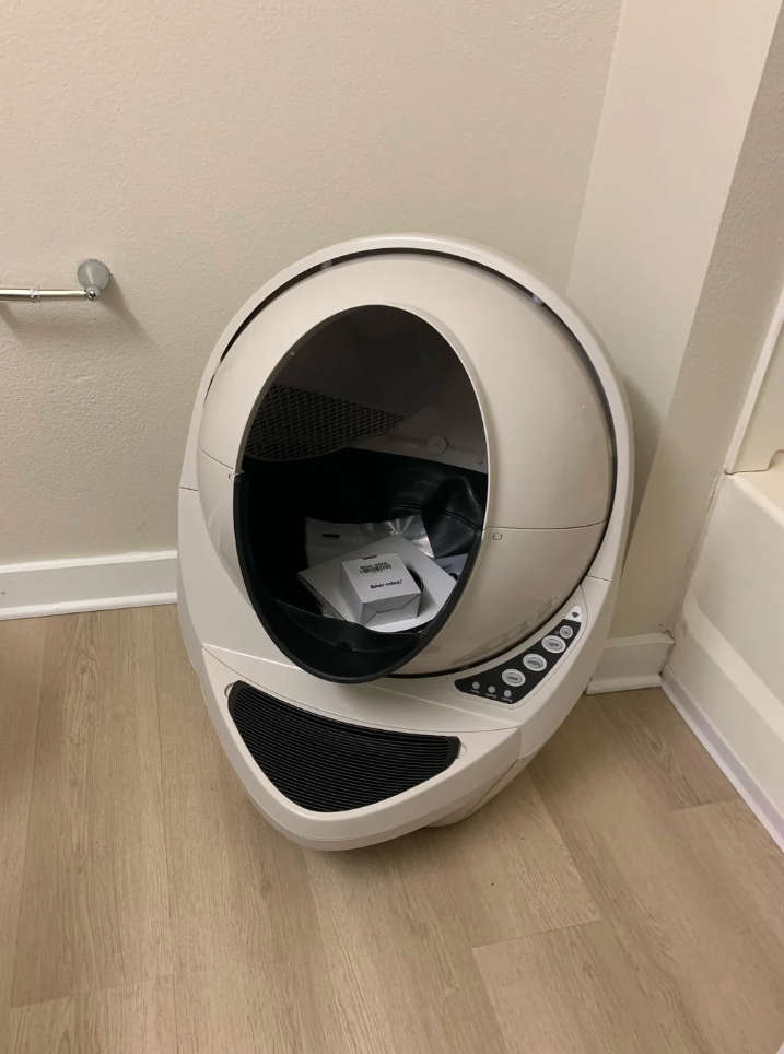 Reddit post shows a modern, spacious litter robot in a bathroom corner. User comments on its large size for their bathroom