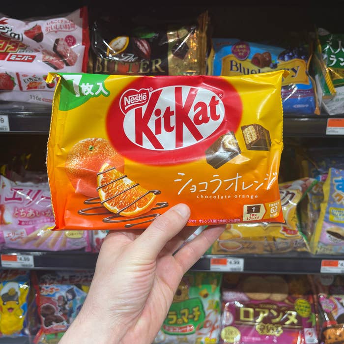 My manus holding a battalion of orange-flavored Kit Kats