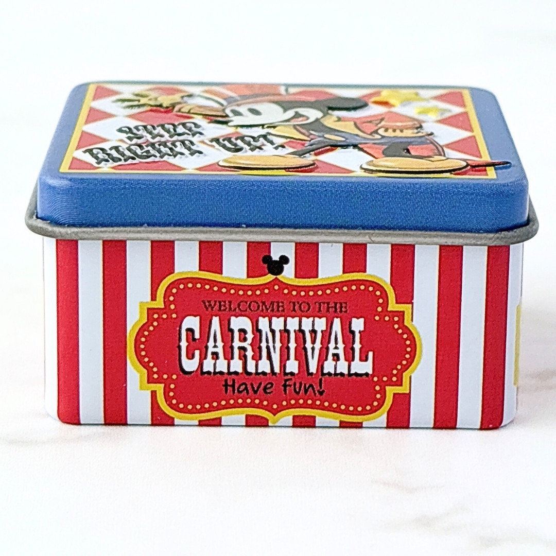 赤と白のストライプの缶、「WELCOME TO THE CARNIVAL」の文字とアニメキャラクターが描かれています。