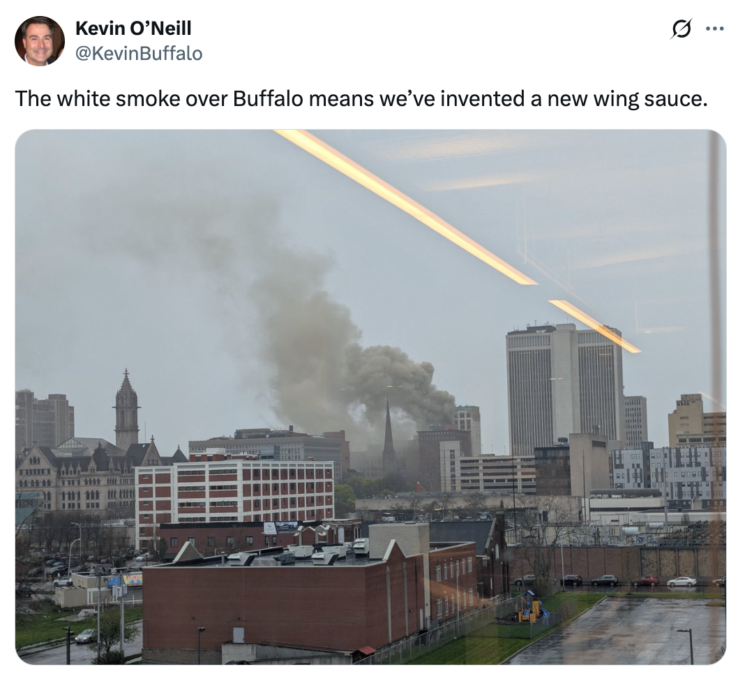 Cityscape view with smoke rising, suggesting humorously that Buffalo has invented a new wing sauce