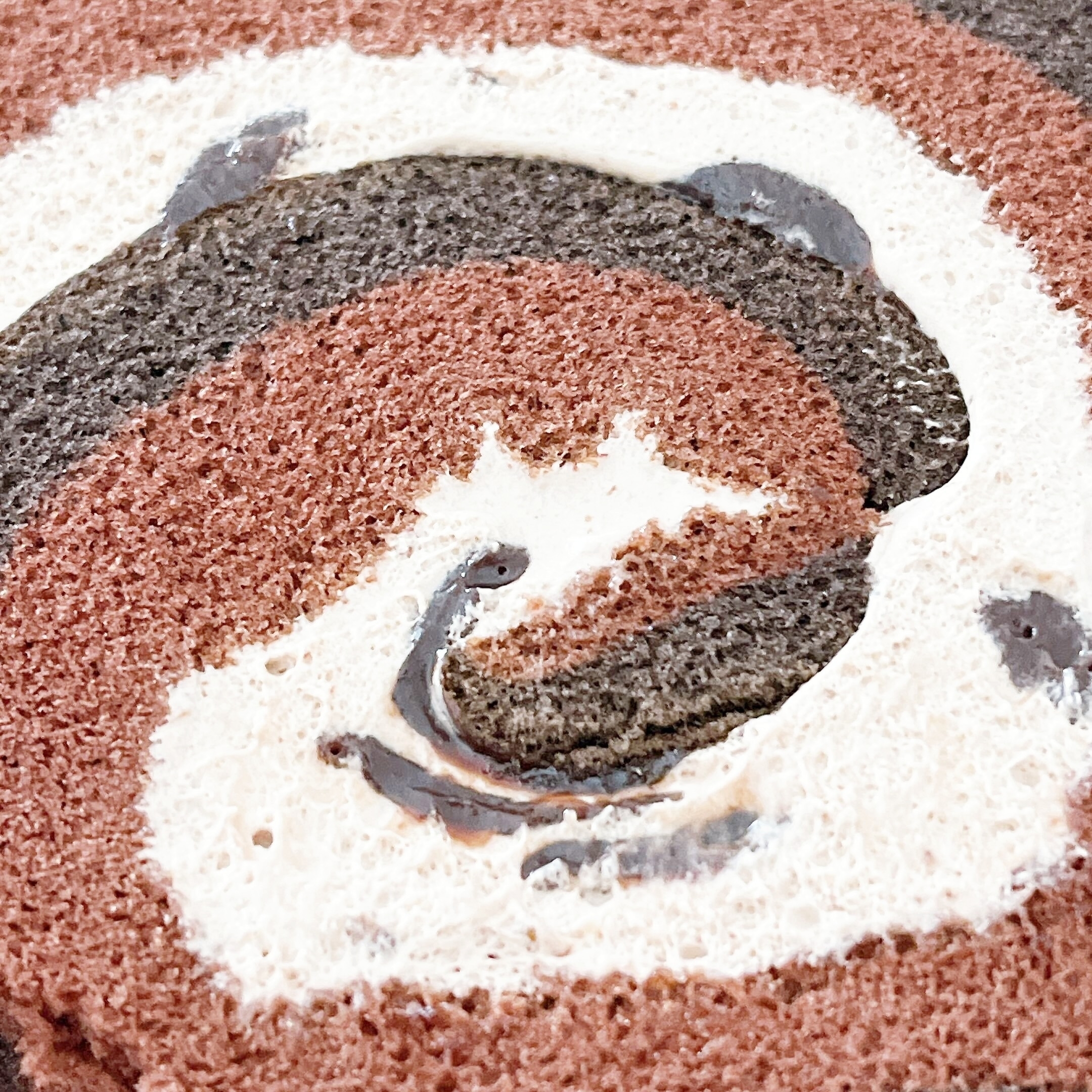 ケーキの渦巻き模様の断面。チョコレートとクリームが層になっているデザイン。