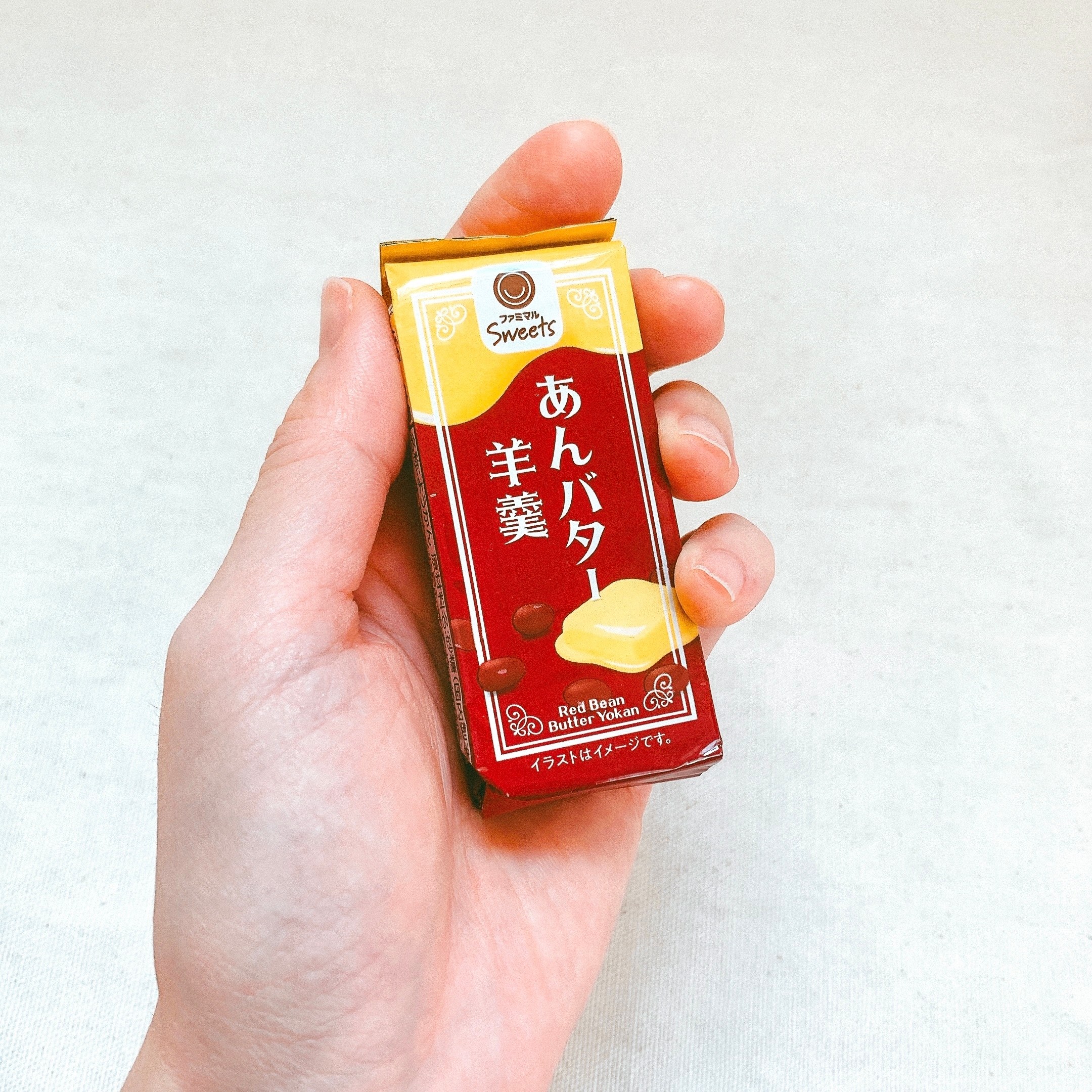 手に持たれたあんバター羊羹のパッケージ。