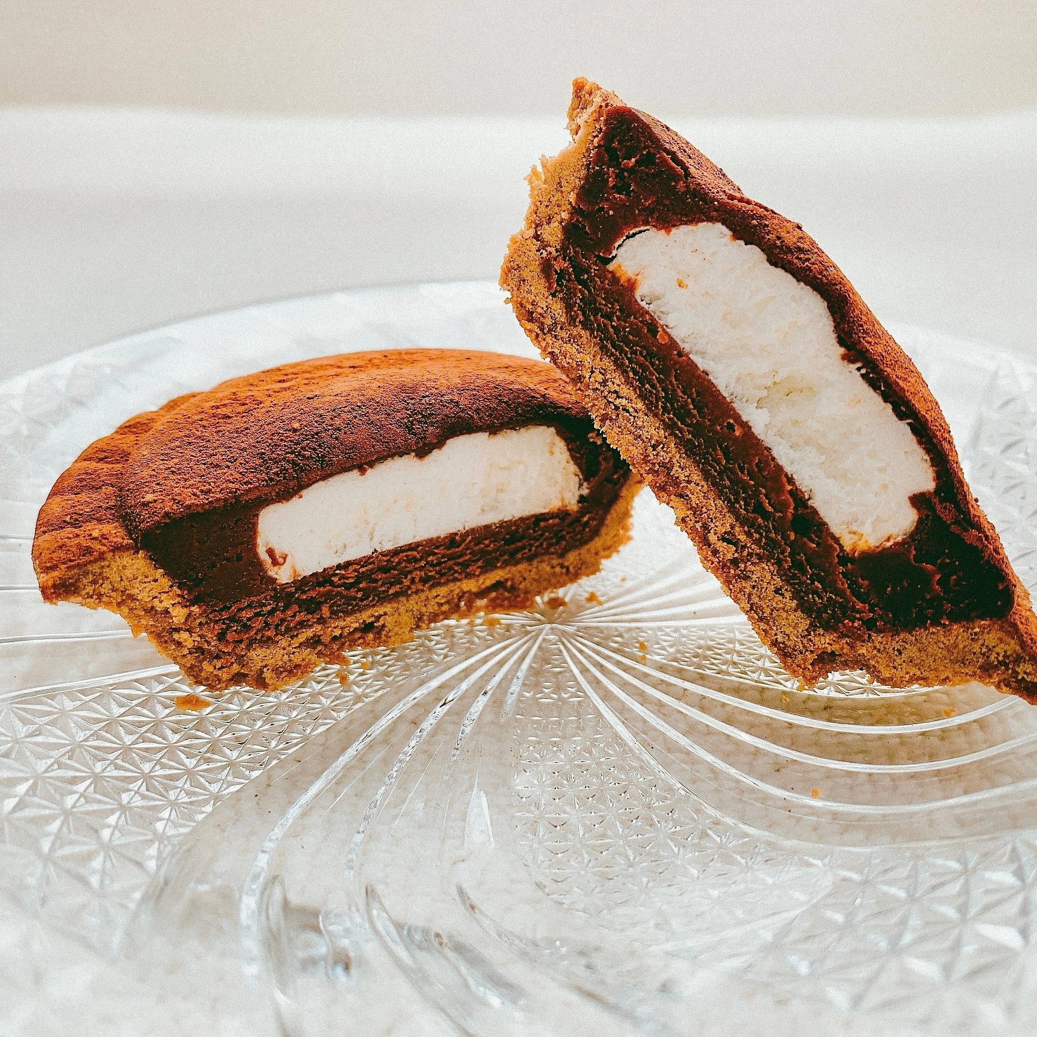 チョコレートタルトがガラス皿に置かれ、断面にクリームが詰まっているのが見える。