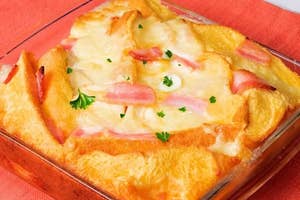 ハムとチーズを挟んで焼かれたベイクドサンドイッチが、ガラスの皿に盛られています。彩りにパセリが振られています。