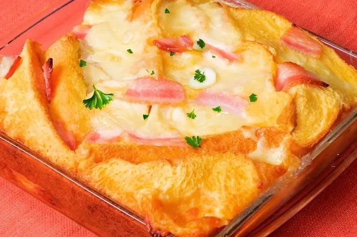 ハムとチーズを挟んで焼かれたベイクドサンドイッチが、ガラスの皿に盛られています。彩りにパセリが振られています。
