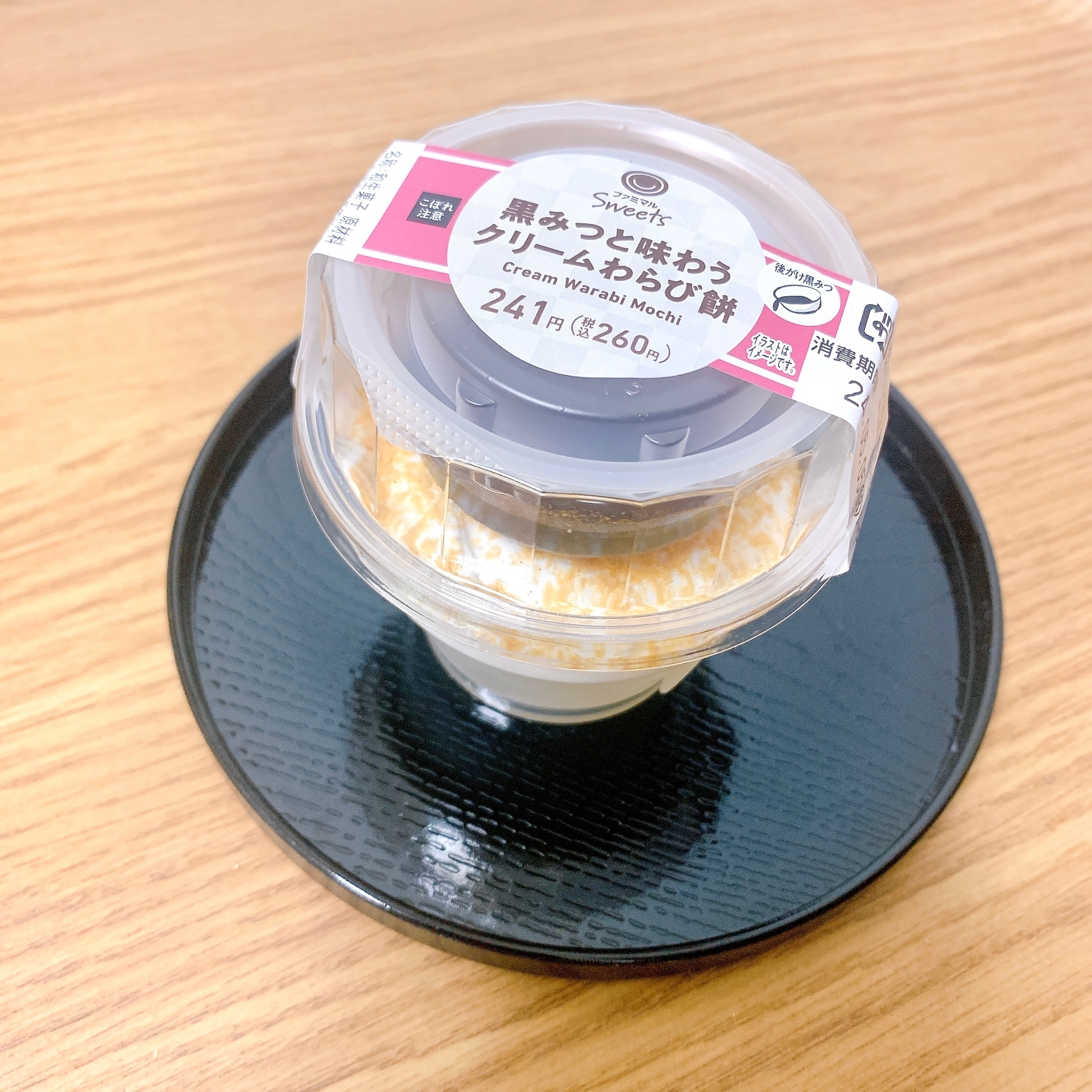 黒みつと味わうクリームわらび餅のパッケージが、小皿にのせられている。価格は260円と表示。