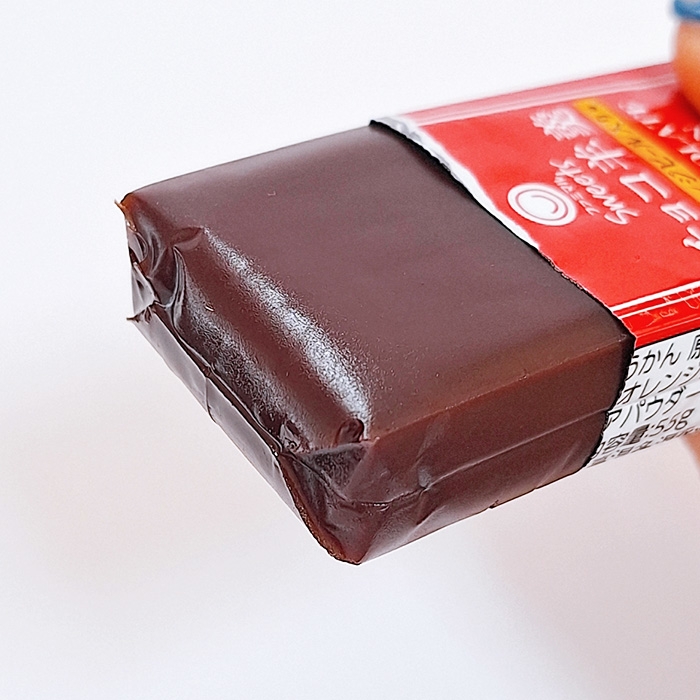 チョコレートでコーティングされた羊羹のパッケージが手に持たれているところ。
