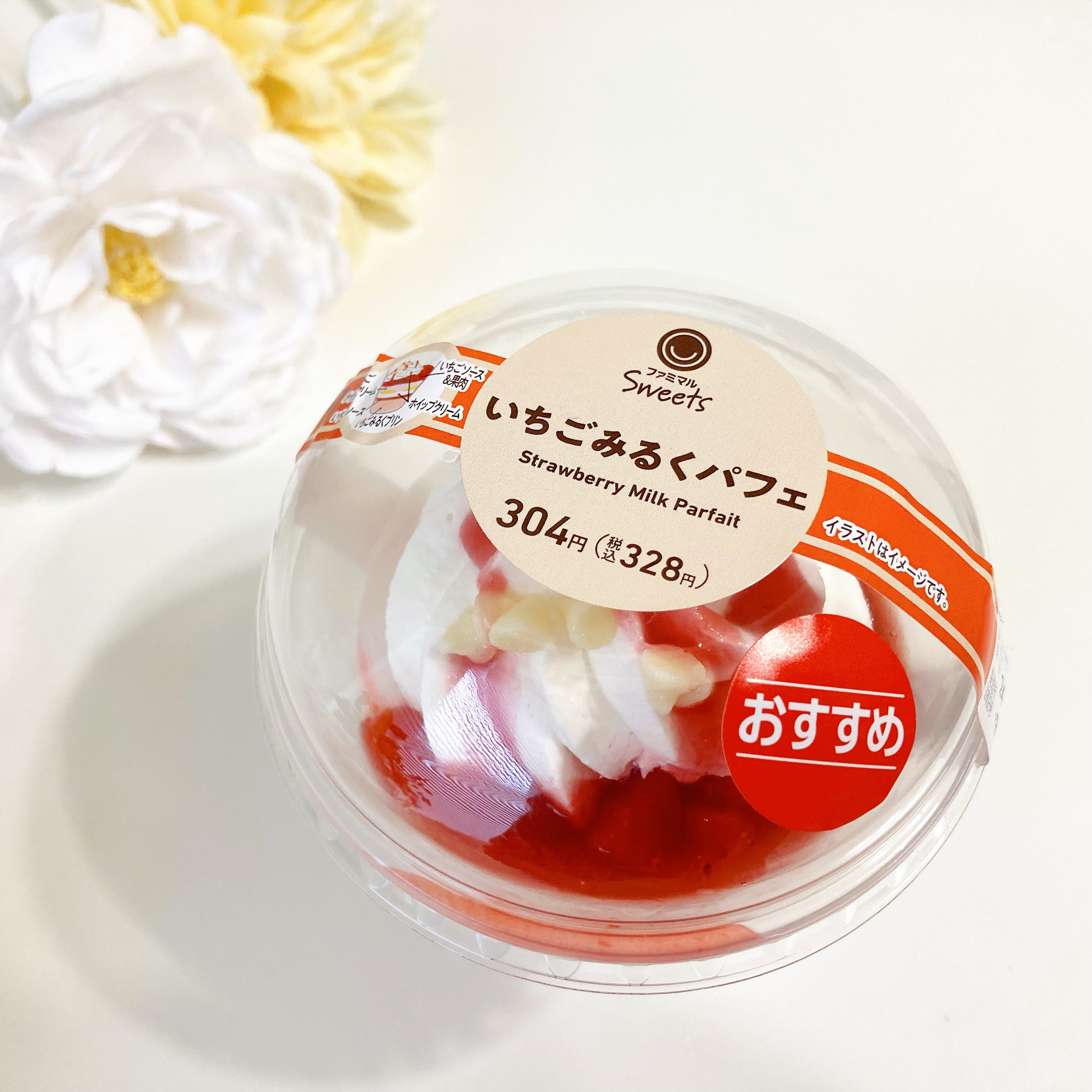 ストロベリーミルクパフェの商品パッケージ。クリームとイチゴが見える。おすすめシール付き。