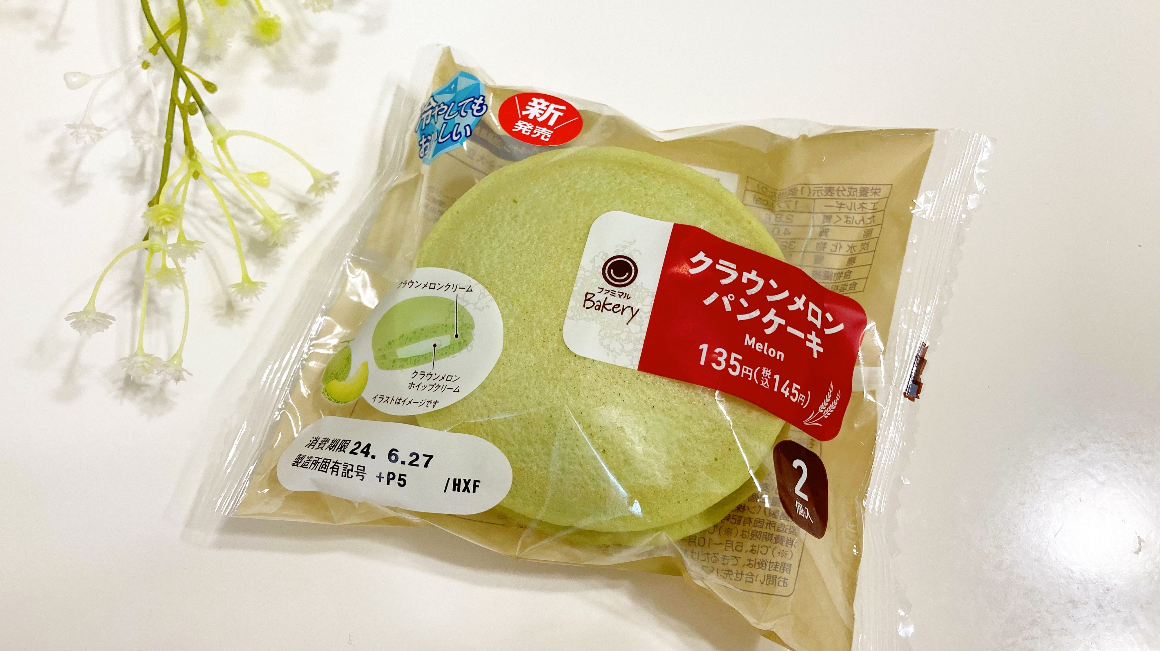 メロン味パンケーキのパッケージがテーブルに置かれている。横に小さな花が置かれている。