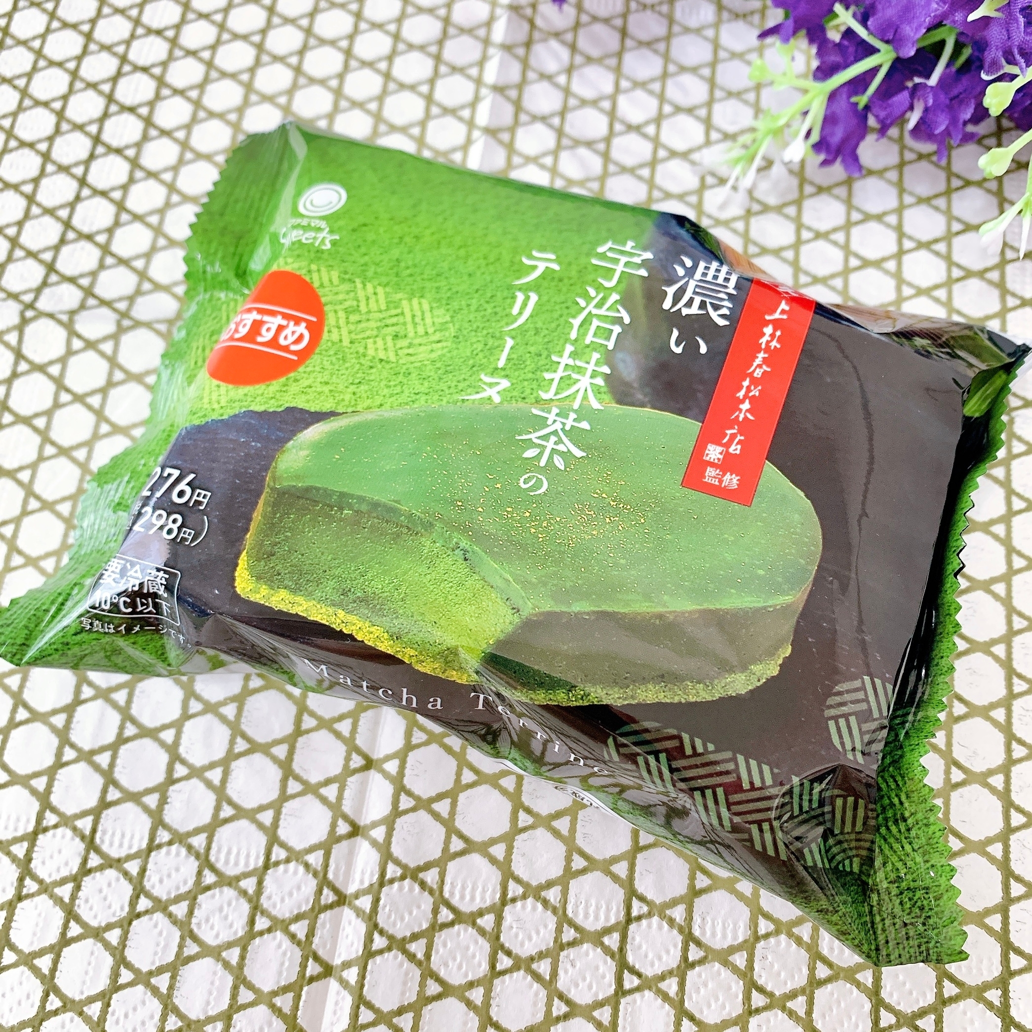 パッケージに入った濃い宇治抹茶のテリーヌケーキがテーブルに置かれている。包装には商品名と価格が記載されている。