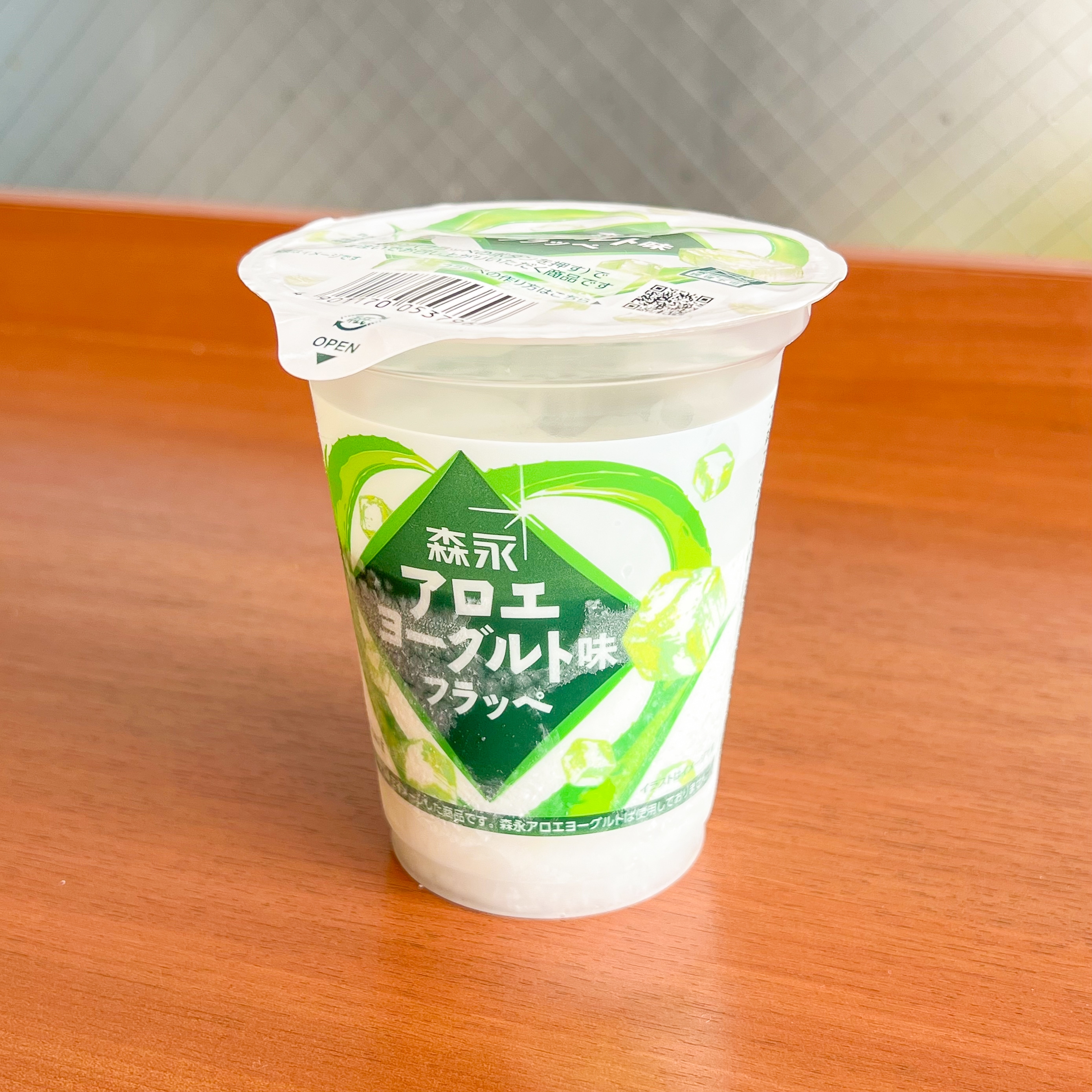 アロエヨーグルト風味アイスのカップ。蓋と側面に商品ロゴやアロエイラストがあります。