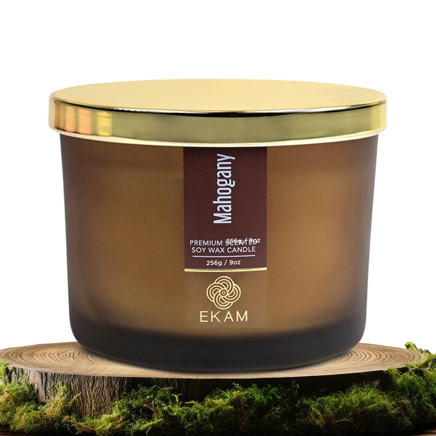 Candle with gold lid labeled &quot;Mahogany Premium Soy Wax Candle&quot; by Ekam, placed on a rustic wooden base