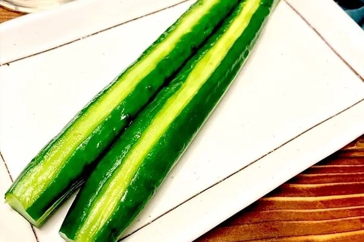 白い皿に盛られた2本のきゅうり。シンプルなプレゼンテーションで、健康的な食材の魅力が強調されています。