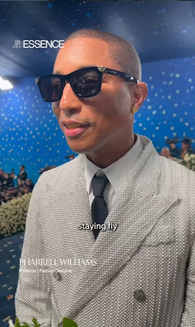 A person in a textured jacket with tie and sunglasses at a formal event