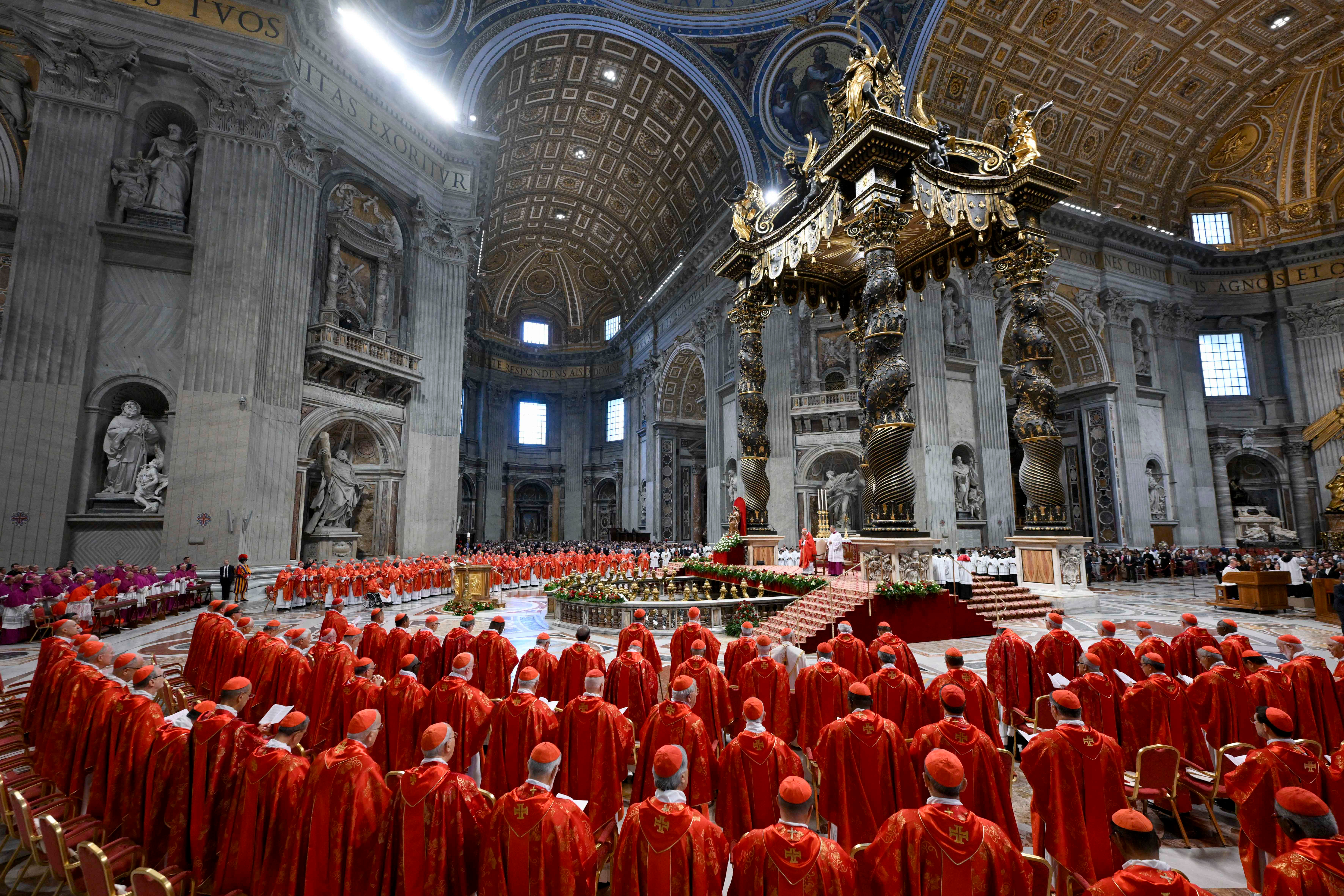 Ceremony at St. Peter's Basilica with many clergy in ornate robes gathered beneath a grand altar