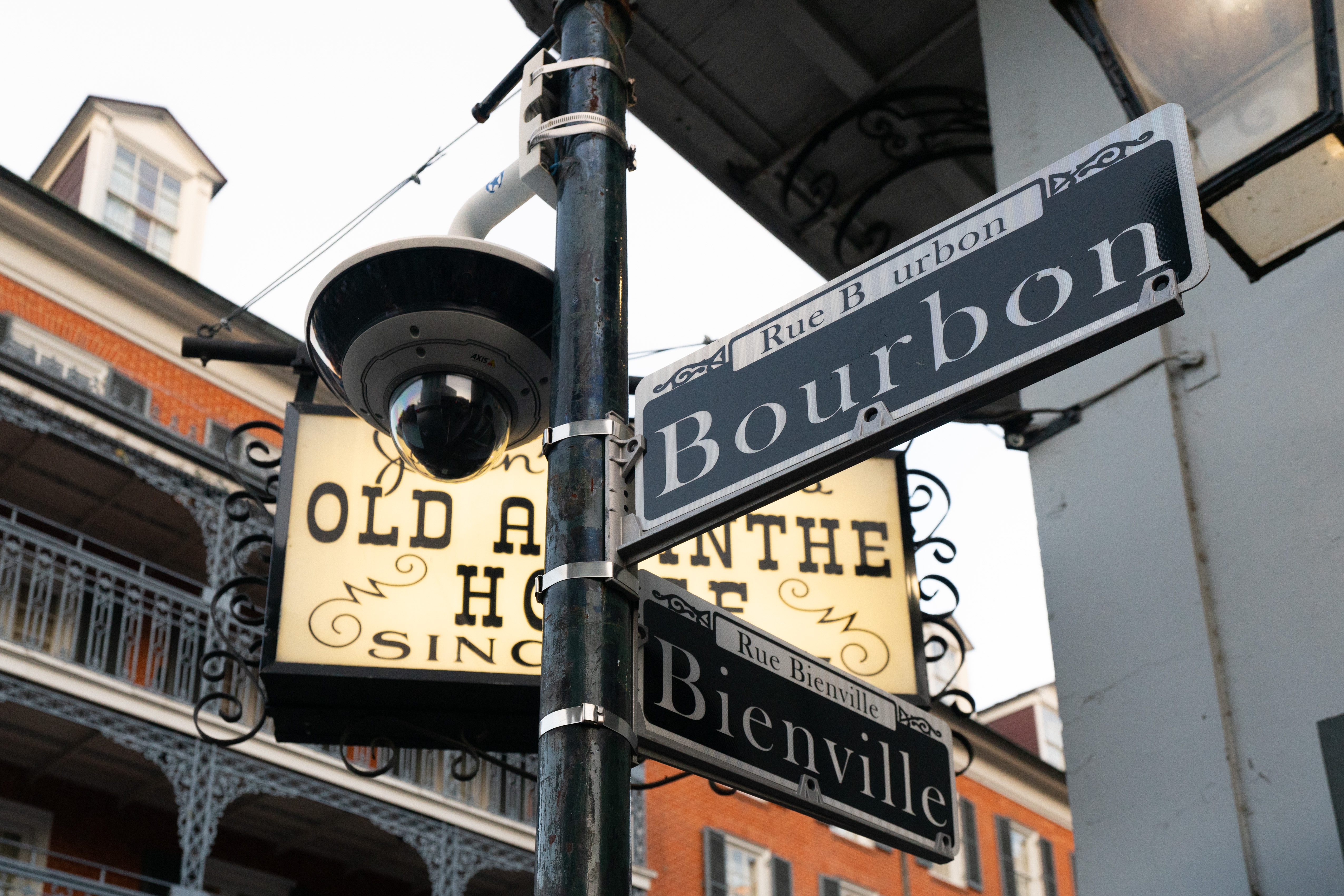 Street signs at Bourbon and Bienville in New Orleans' French Quarter, with a historic building in the background