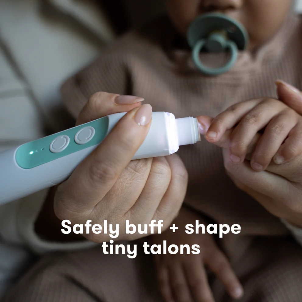 Adult gently trims baby's nails with a safe electronic tool. Text: "Safely buff + shape tiny talons." Baby with pacifier in background