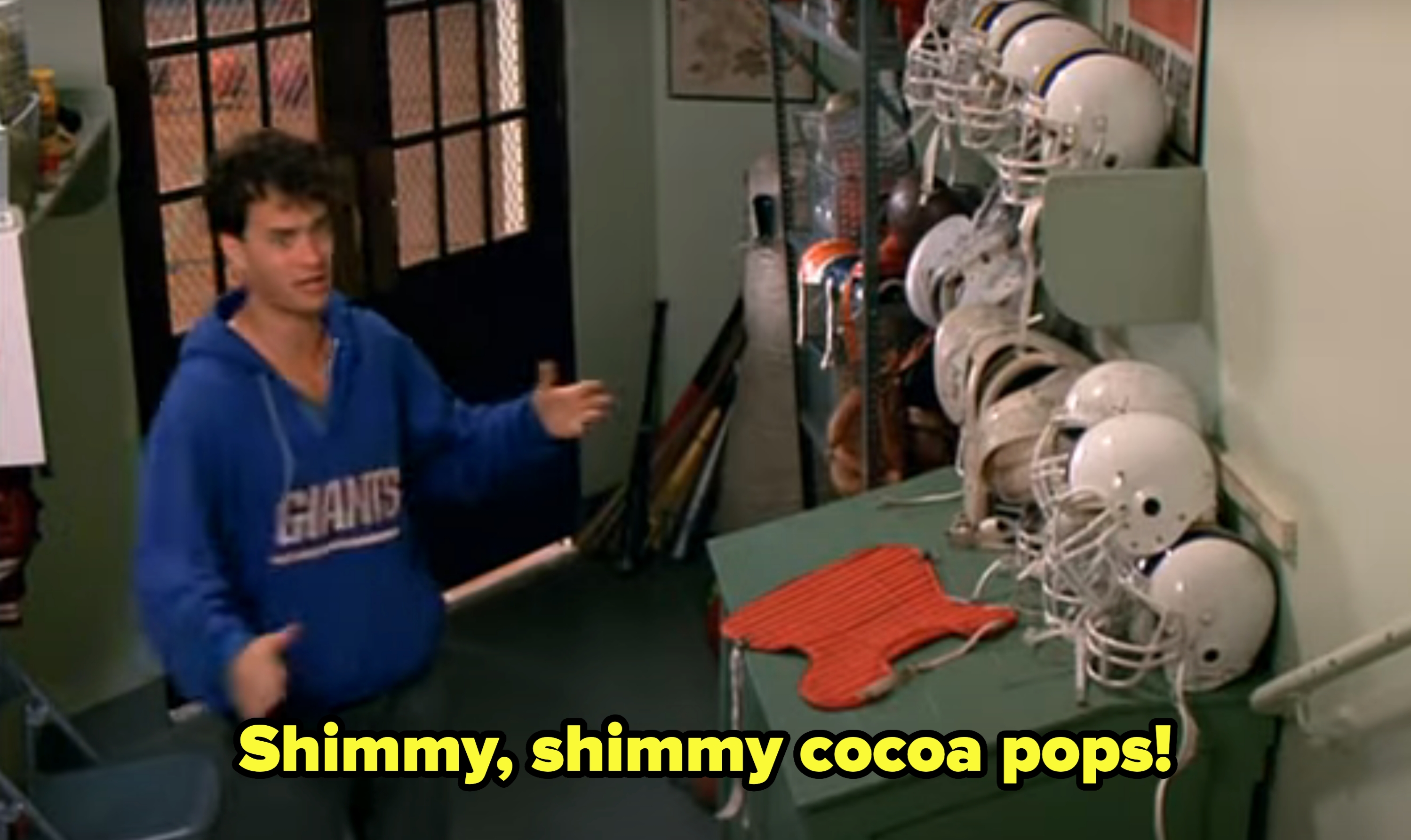 Tom in a casual Giants hoodie enthusiastically gestures next to football helmets, with the subtitle &quot;Shimmy, shimmy cocoa pops!&quot;