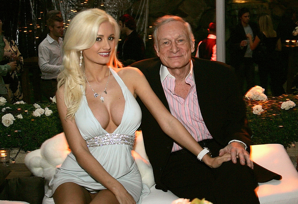 I don't know who they are, but a woman in an elegant gown sits beside an older man in a suit, together at an upscale event