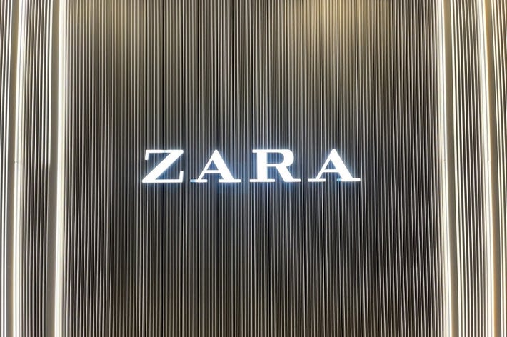 ZARAの看板。縦のラインが背景にあり、店舗の入口を示しているようです。