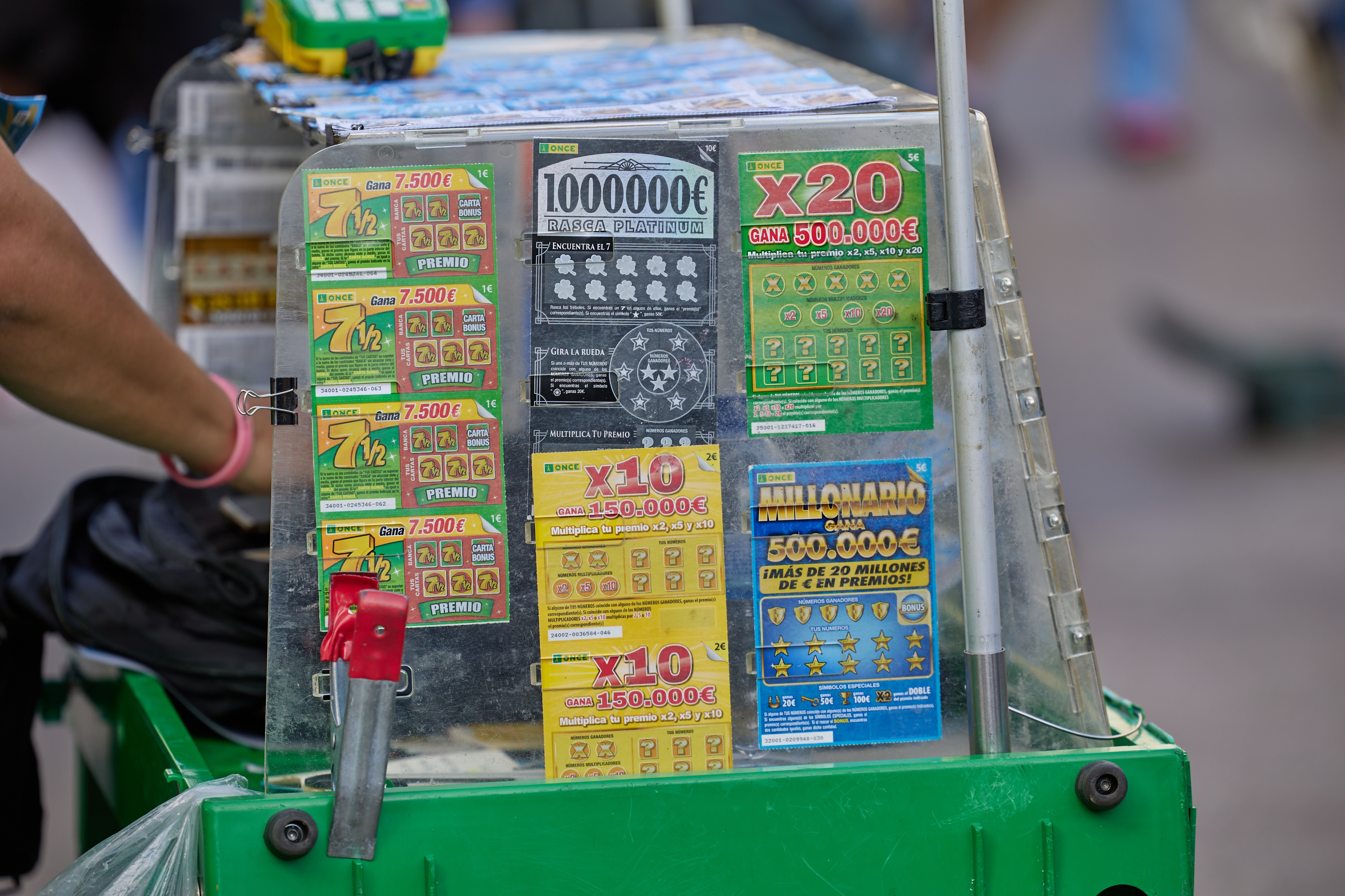 A variety of lottery tickets displayed on a stand, including scratch-off games offering different prize amounts and jackpot options