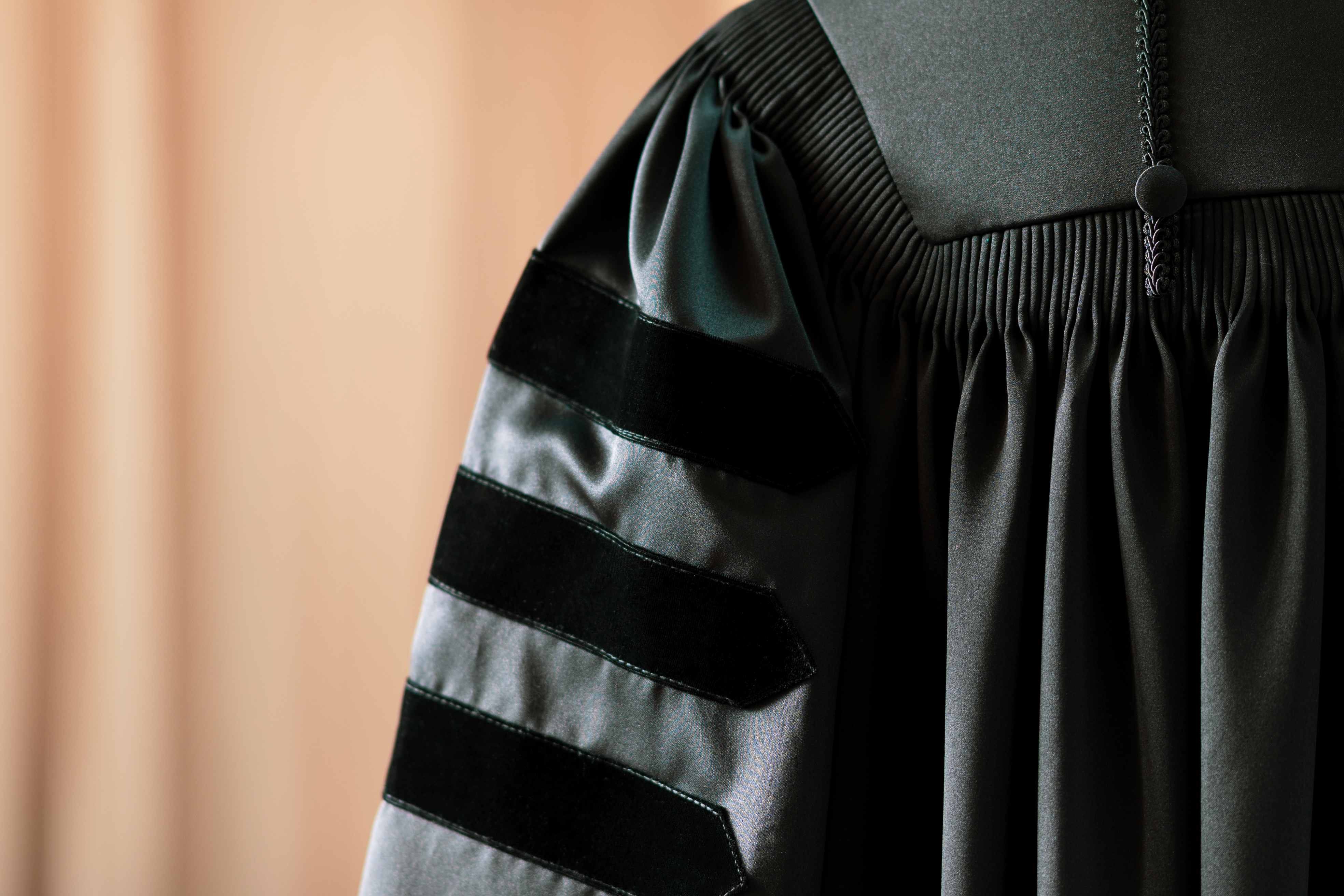 Academic regalia with velvet bands, typically worn for doctoral graduations, symbolizes achievement and professional advancement