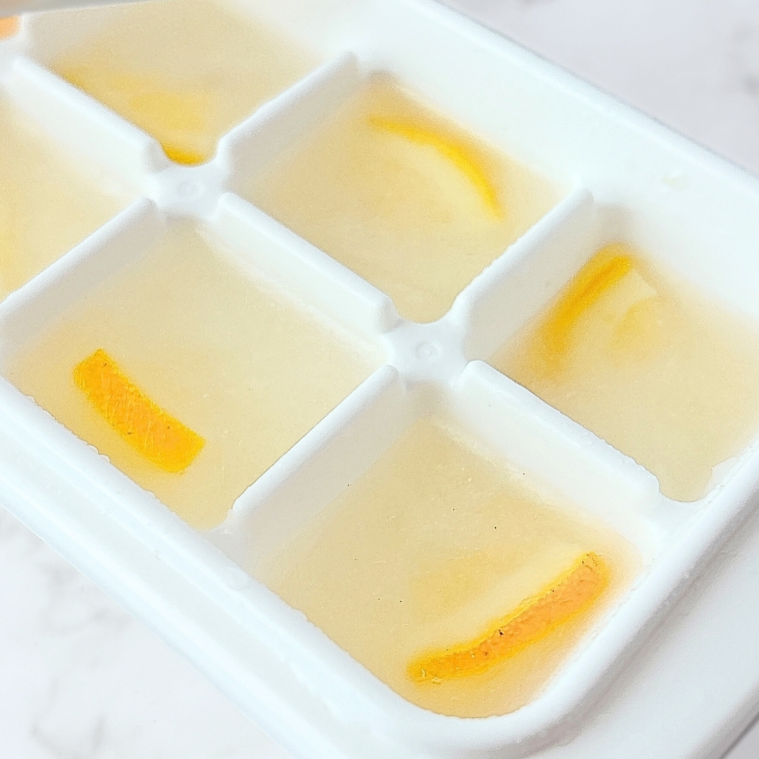 氷の中に薄く切られたオレンジが入った製氷皿。