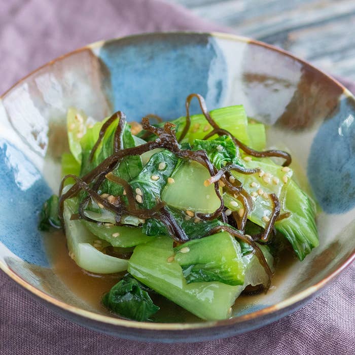 青梗菜と海藻の和風サラダが器に盛られている。上にはゴマが振りかけられている。